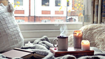 Cozy home. Candles, book and cup of tea